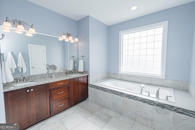 bathroom with double vanity, a garden tub, and a sink