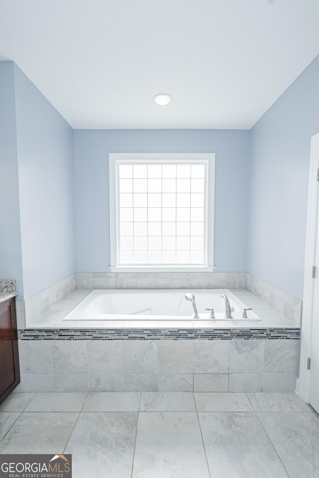 bathroom featuring vanity and a bath