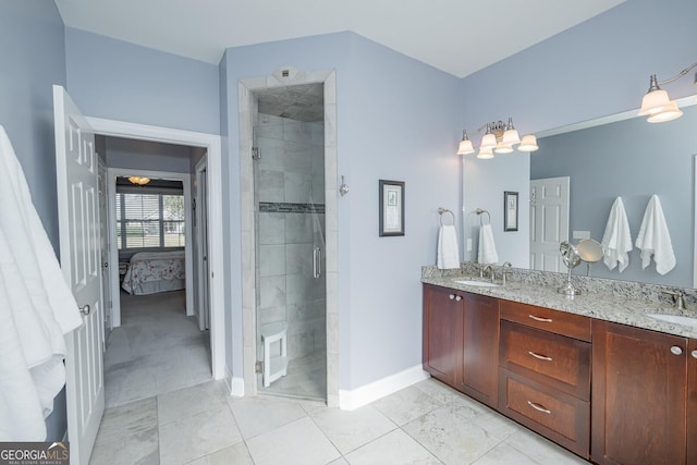 ensuite bathroom with double vanity, a stall shower, a sink, and ensuite bathroom