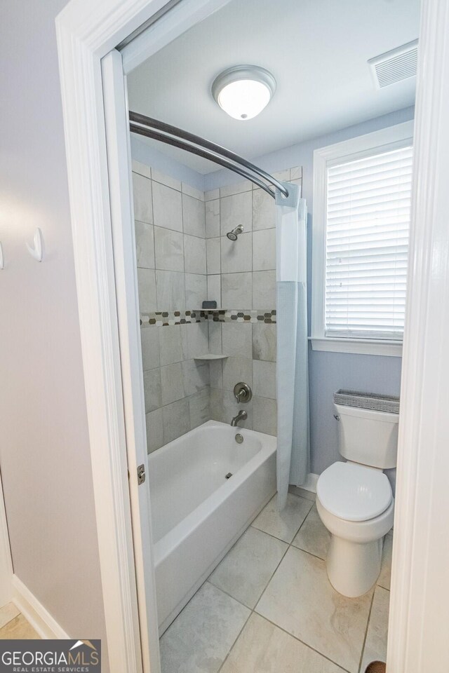 full bath with shower / bath combo, baseboards, visible vents, toilet, and tile patterned floors