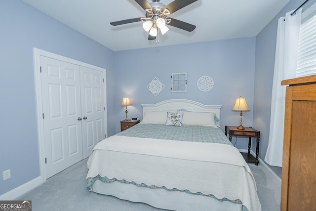 bedroom with carpet floors, ceiling fan, baseboards, and a closet