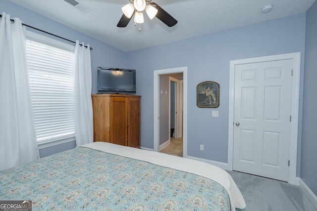 bedroom with a ceiling fan, light colored carpet, visible vents, and baseboards