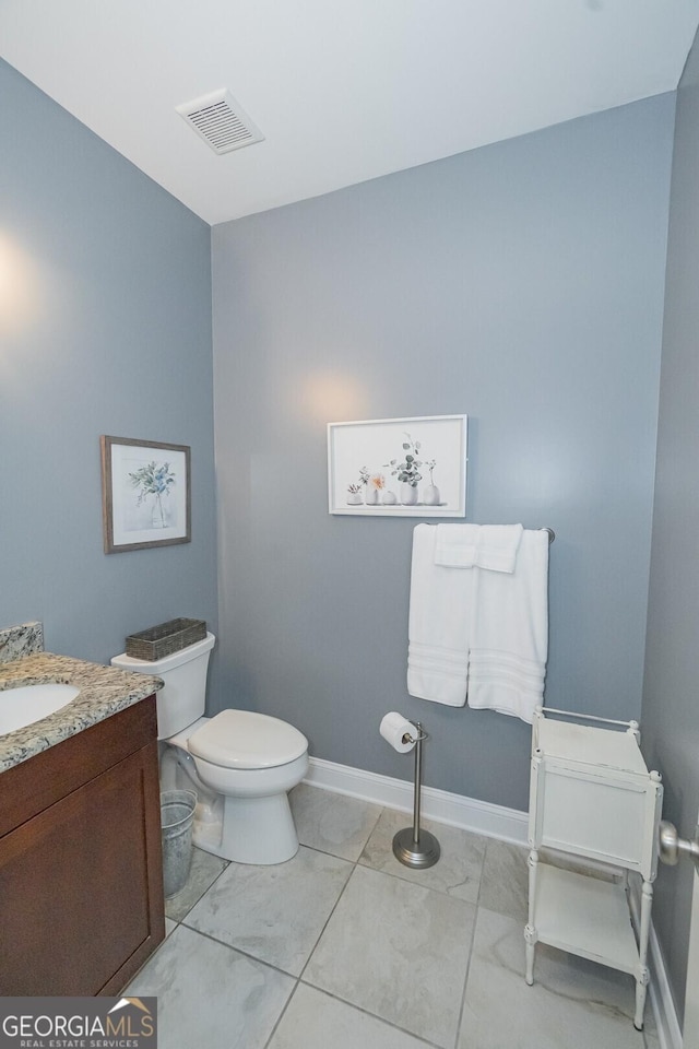 half bathroom featuring toilet, baseboards, visible vents, and vanity