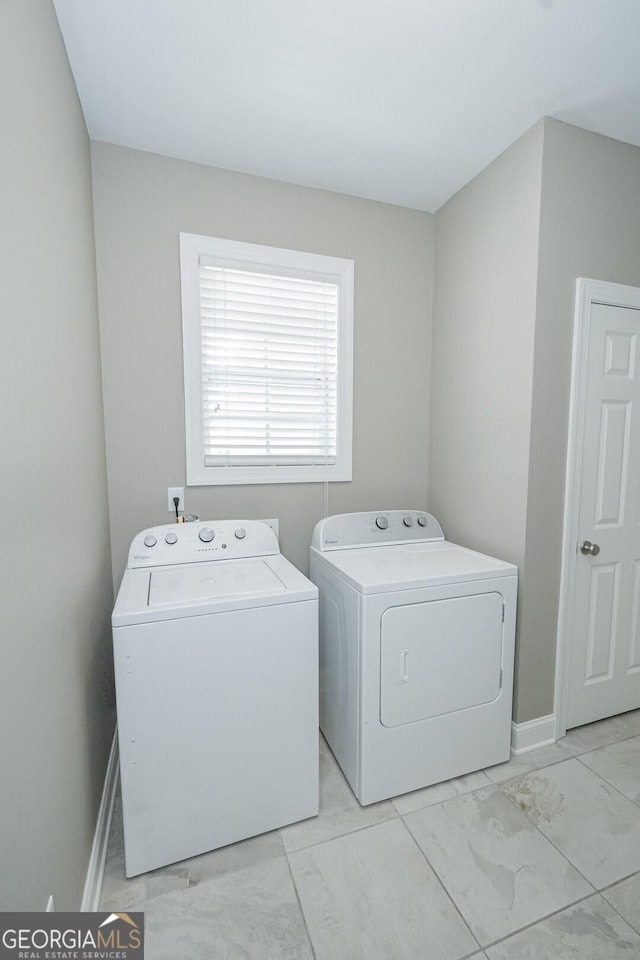 laundry area with laundry area, washing machine and dryer, marble finish floor, and baseboards