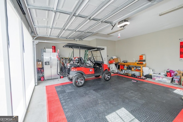 garage featuring stainless steel fridge and a garage door opener