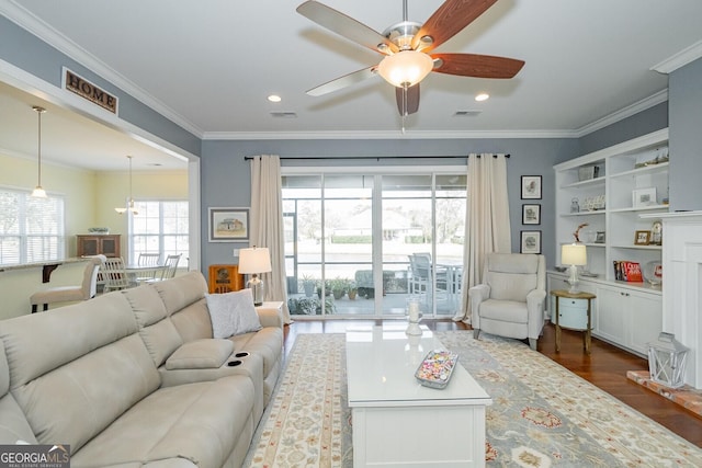 living room with crown molding, recessed lighting, visible vents, and dark wood finished floors