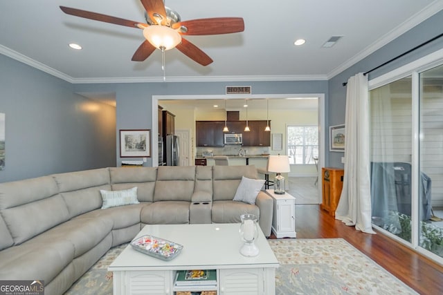 living room featuring dark wood-style floors, recessed lighting, visible vents, and ornamental molding