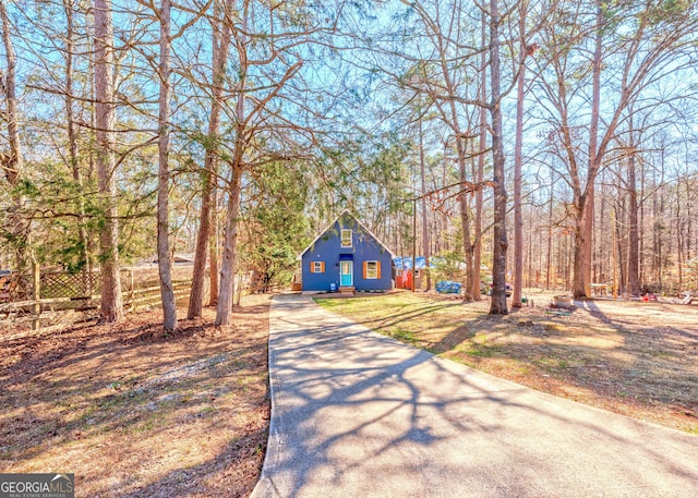 view of front facade featuring fence and driveway