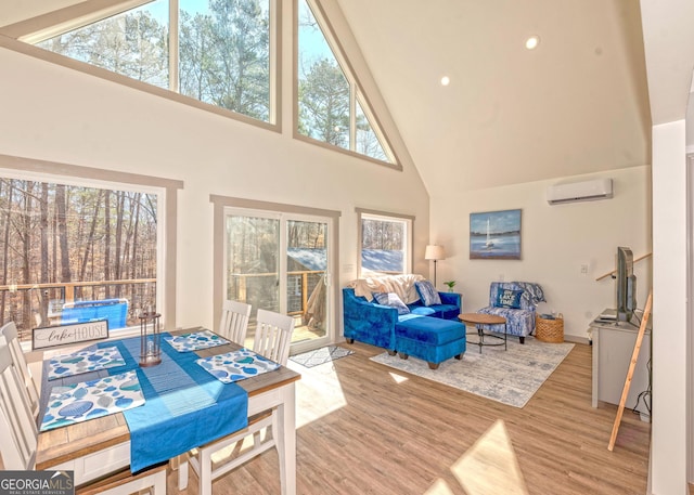 living area featuring recessed lighting, high vaulted ceiling, wood finished floors, and a wall mounted air conditioner