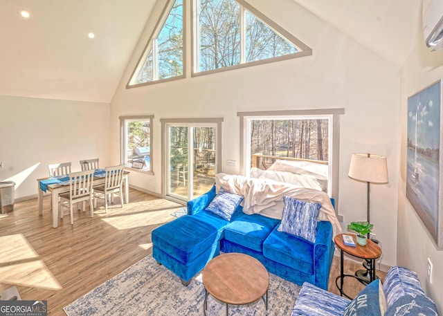 living room with recessed lighting, a wall mounted AC, wood finished floors, high vaulted ceiling, and baseboards