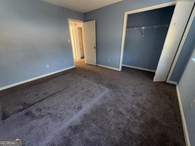 unfurnished bedroom featuring a closet, dark carpet, and baseboards