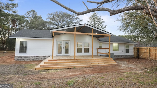 back of house with fence, a deck, and roof with shingles