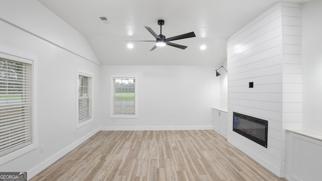 unfurnished living room featuring baseboards, visible vents, vaulted ceiling, light wood-type flooring, and a fireplace