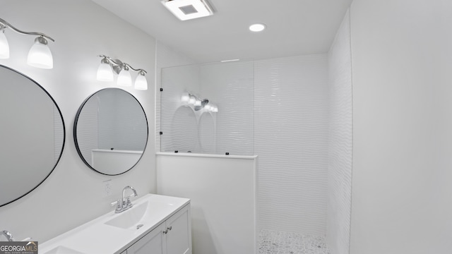 bathroom featuring a walk in shower, visible vents, and vanity