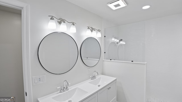 full bath with double vanity, a sink, and visible vents