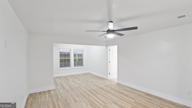 empty room featuring ceiling fan, light wood-type flooring, visible vents, and baseboards