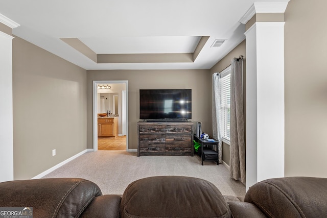 carpeted living room featuring baseboards, visible vents, and a tray ceiling