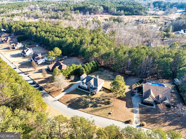 birds eye view of property featuring a forest view