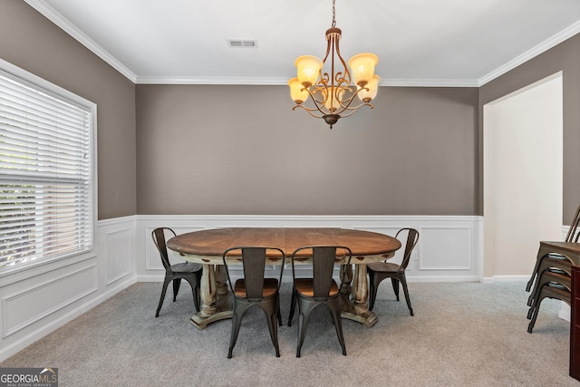 dining area featuring carpet, visible vents, a decorative wall, an inviting chandelier, and ornamental molding