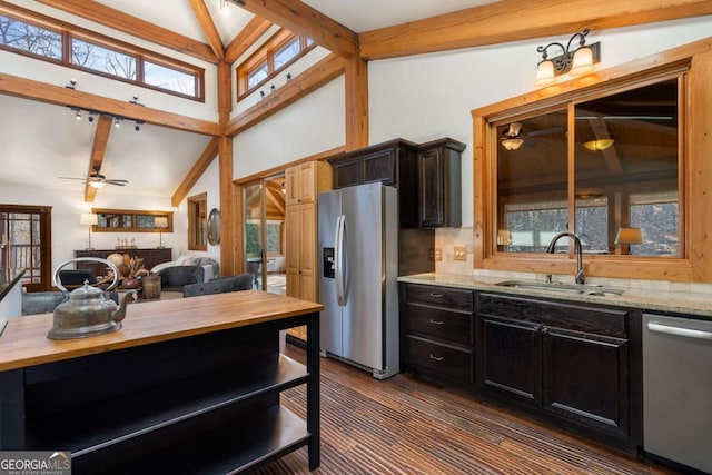 kitchen featuring vaulted ceiling with beams, stainless steel appliances, wooden counters, a sink, and ceiling fan