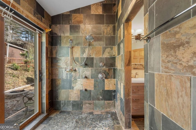 full bathroom featuring lofted ceiling, tiled shower, and vanity