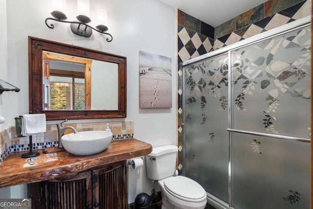 bathroom with toilet, a stall shower, decorative backsplash, and vanity