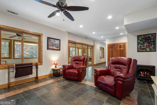 living room with a wealth of natural light, baseboards, and stone tile floors