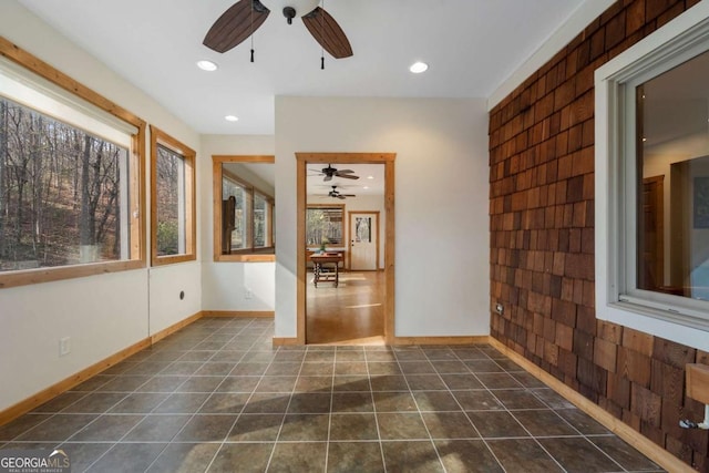 unfurnished room featuring recessed lighting, dark tile patterned floors, and baseboards