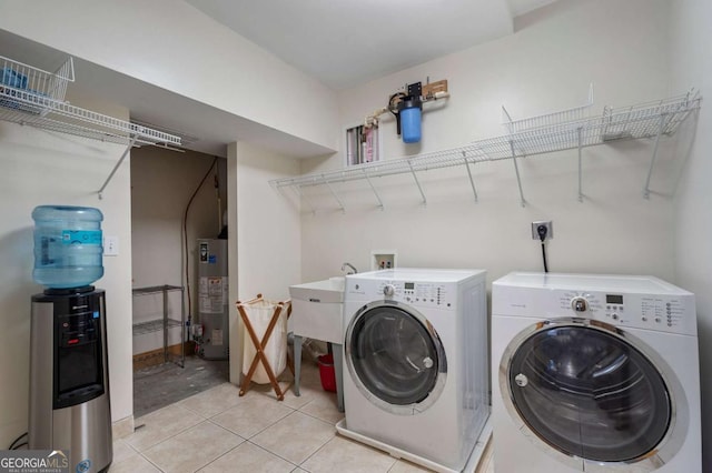 clothes washing area with laundry area, light tile patterned floors, water heater, and separate washer and dryer