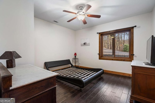 bedroom featuring a ceiling fan, visible vents, baseboards, and wood finished floors