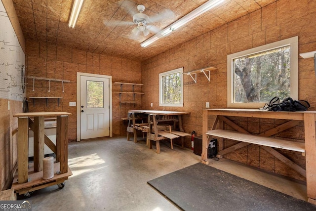 miscellaneous room featuring ceiling fan, concrete floors, and a workshop area