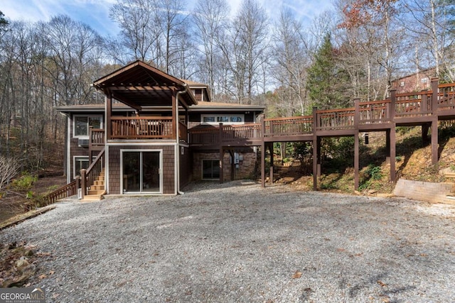 rear view of property with stairs and a wooden deck