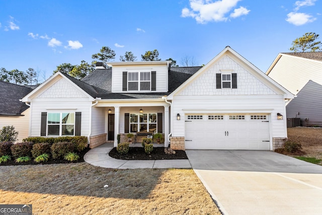 craftsman inspired home featuring covered porch, roof with shingles, driveway, and central air condition unit