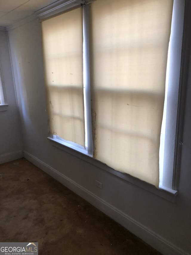 unfurnished room with baseboards