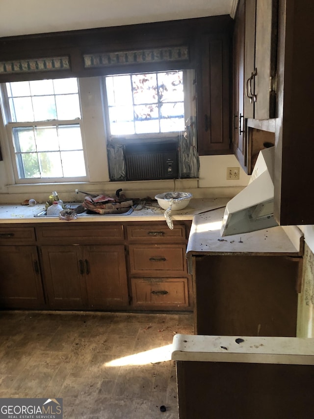 kitchen featuring light wood-type flooring, light countertops, and dark brown cabinetry