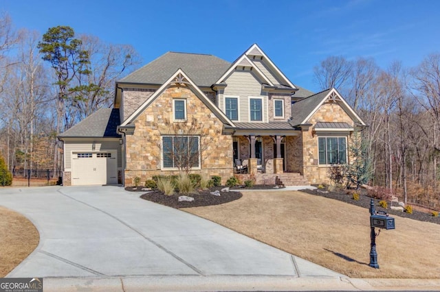 craftsman-style home featuring driveway, a garage, metal roof, covered porch, and a standing seam roof