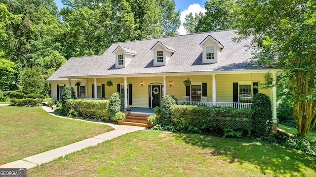 cape cod house with a shingled roof, a porch, and a front yard