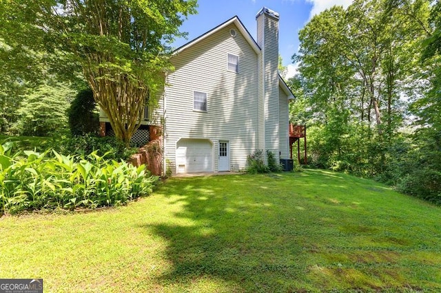 view of property exterior with a deck, a yard, a chimney, and an attached garage