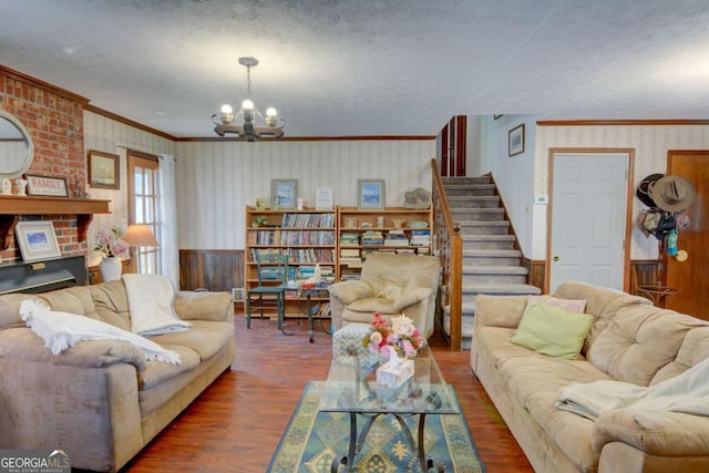 living room featuring wallpapered walls, stairway, dark wood-type flooring, and a wainscoted wall