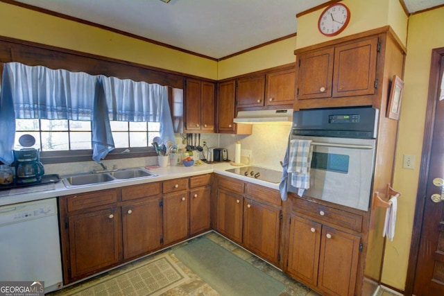 kitchen with under cabinet range hood, white dishwasher, light countertops, and oven