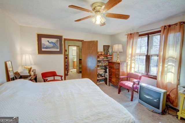 bedroom featuring a ceiling fan, a textured ceiling, and light colored carpet