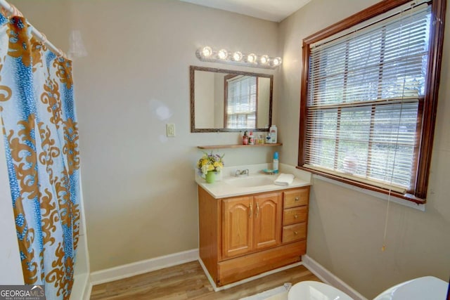 bathroom with baseboards, vanity, toilet, and wood finished floors