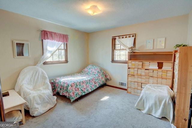 carpeted bedroom featuring visible vents, baseboards, and multiple windows