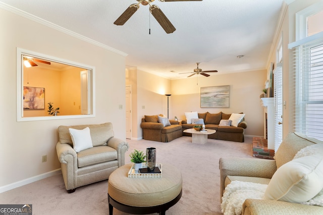 carpeted living room featuring baseboards, ornamental molding, and a ceiling fan