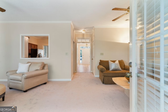 carpeted living area with baseboards, ornamental molding, and ceiling fan