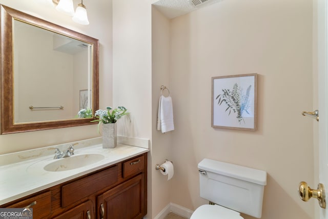 bathroom featuring visible vents, vanity, and toilet