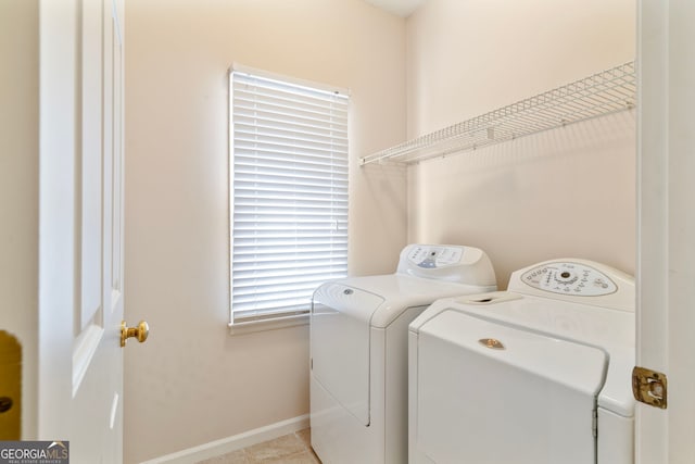 washroom with laundry area, independent washer and dryer, and baseboards