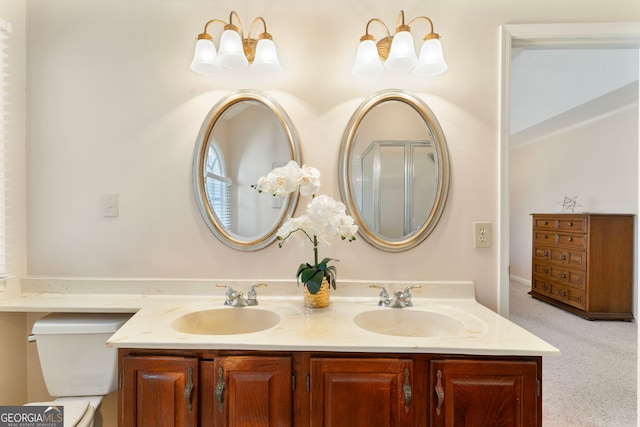 bathroom featuring double vanity, toilet, and a sink