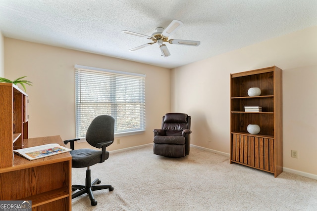 carpeted office featuring ceiling fan, baseboards, and a textured ceiling