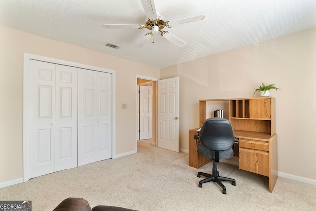 carpeted office with a ceiling fan, baseboards, visible vents, and a textured ceiling